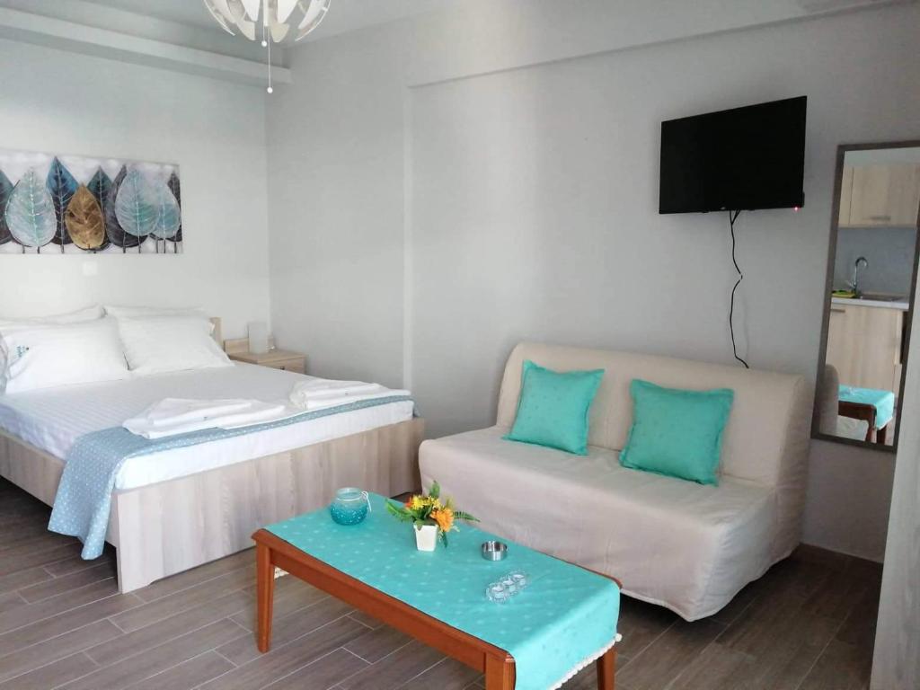 帕拉利亚狄奥尼索PERLA apartments的客房设有两张床、一张沙发和一台电视。