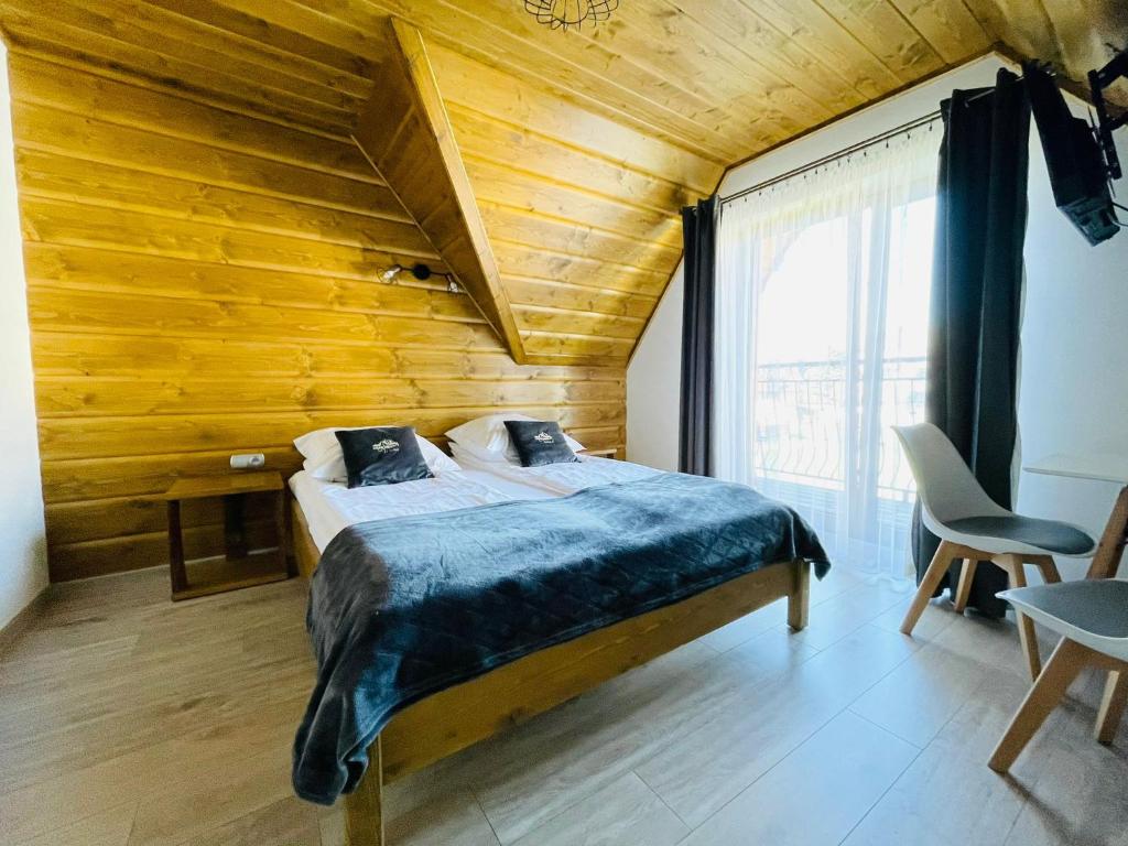波罗宁Gąsienicowy Widok的一间卧室设有一张木天花板床。