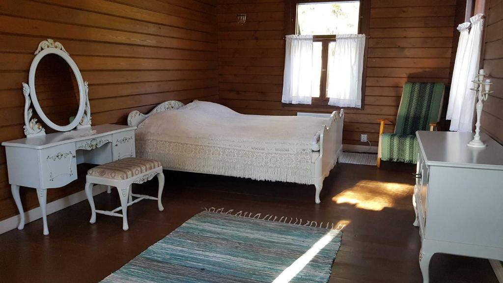 TuorilaNikolain tupa, vanha hirsitalo的一间卧室配有一张床、一个梳妆台和镜子