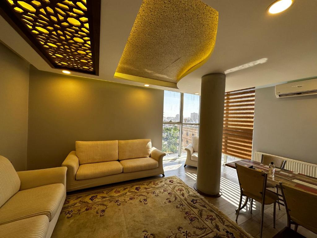 MidyatXANTHOS APART HOTEL Midyat Merkezde的客厅配有沙发和桌子