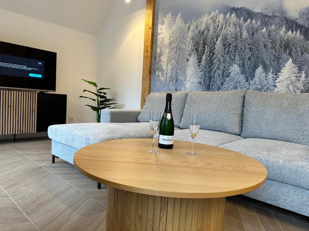 斯克拉斯卡波伦巴Apartament Górska Osada 21的客厅配有一张桌子,并提供一瓶葡萄酒