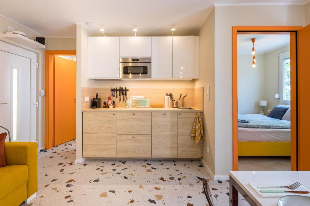 扎马迪Balatonic Orange的一间厨房,配有白色的橱柜和一张位于客房内的床