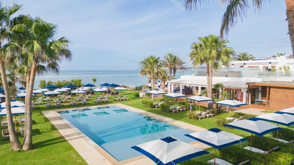 米乔尔海滩Gecko Hotel & Beach Club, a Small Luxury Hotel of the World的享有度假村的空中景致,设有游泳池和遮阳伞。