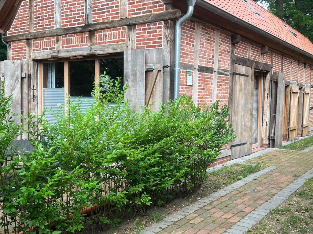 BadbergenEichenhof Artland的旧砖砌的建筑,带有窗户和灌木