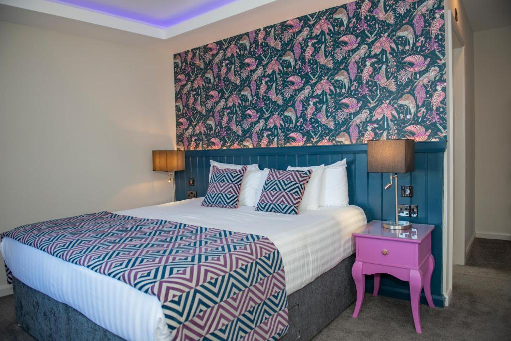 韦克斯福德Crown Quarter的一间卧室配有一张带花卉壁纸的大床