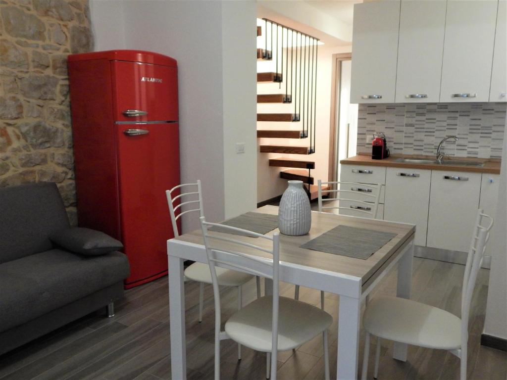 包内伊Casa Foddis - Bed and View的厨房配有桌子和红色冰箱