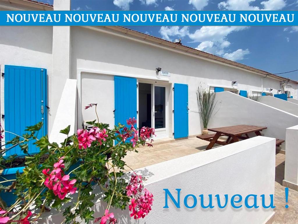 阿尔勒Auberge des Plaines - Appartements avec terrasse的前面有蓝色门和鲜花的房子