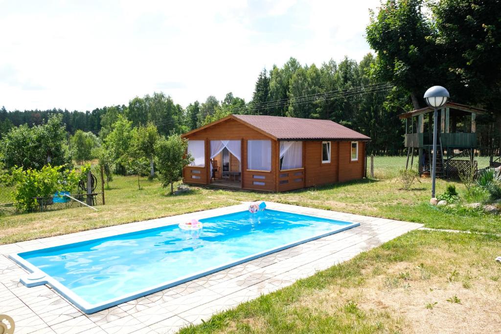 SkórczMark VI Mirotki 12 ImWald Bory Tucholskie的一座带游泳池和小屋的房子