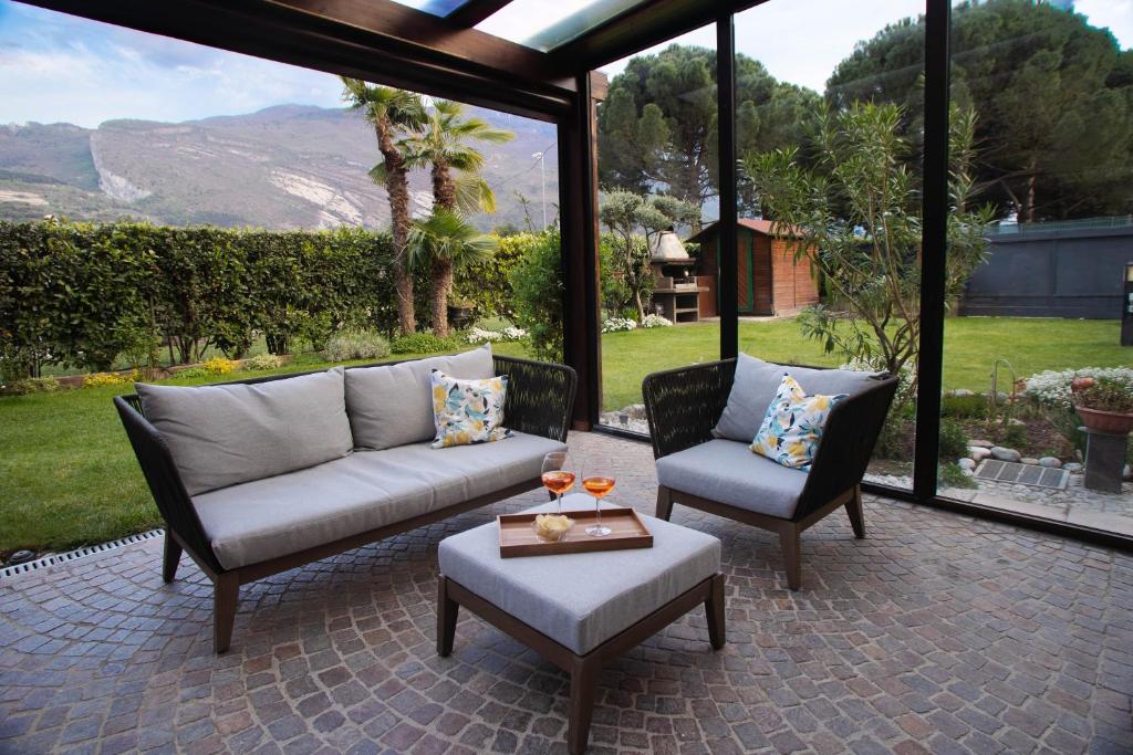 托尔博莱Villetta al lago的庭院配有两把椅子、一张沙发和一张桌子