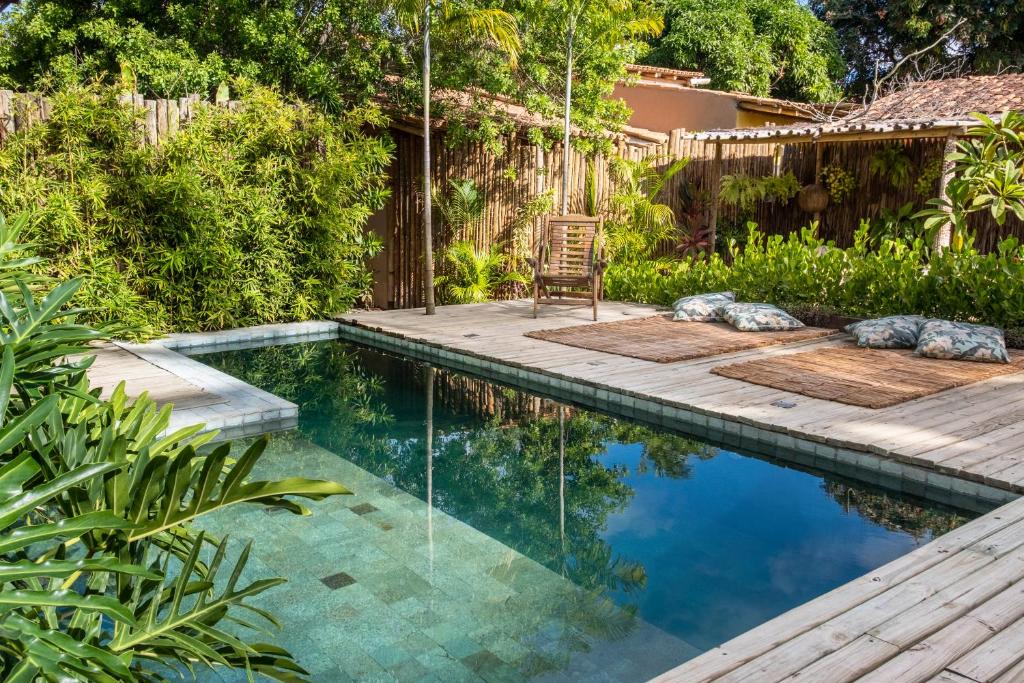 卡拉伊瓦Casa das Conchas Caraiva的后院的游泳池,设有甲板和椅子