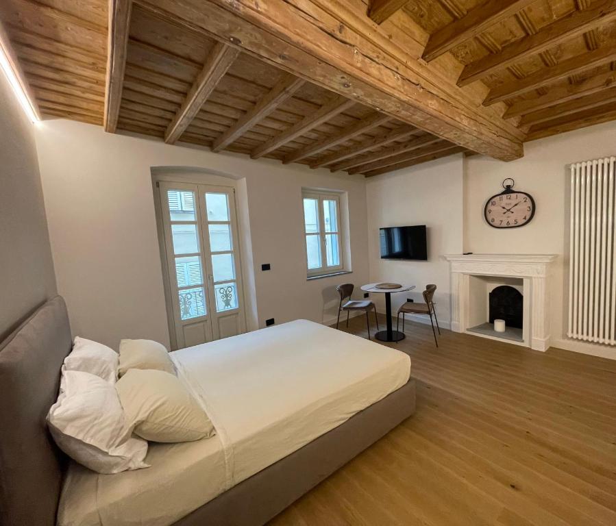 库尼奥La Dimora del Brocante的一间卧室设有一张大床和一个壁炉