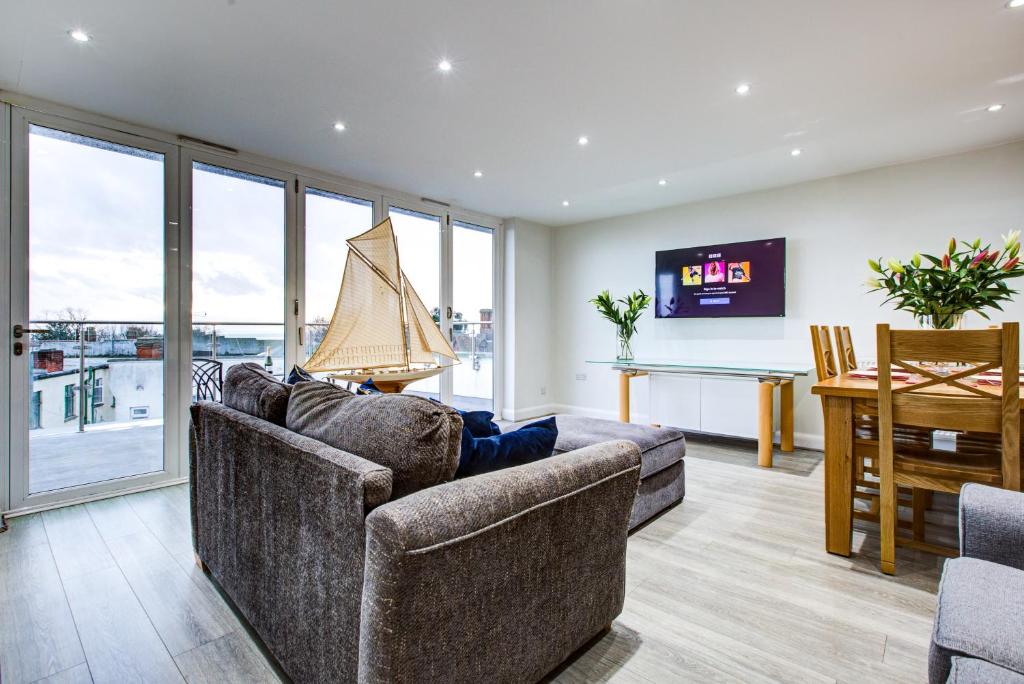 滨海利leigh Penthouse Apartment的一间带两张沙发和一张桌子的客厅以及一间用餐室