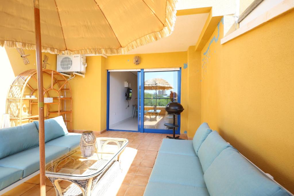 坎波阿莫Campoamor Seaview的带沙发和遮阳伞的客厅