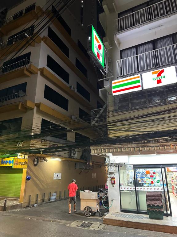 曼谷Dreamcatcher Bangkok的一名男子站在一栋建筑物前