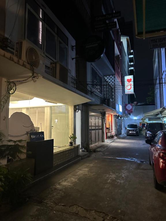 曼谷Dreamcatcher Bangkok的夜间在商店前停车的城市街道