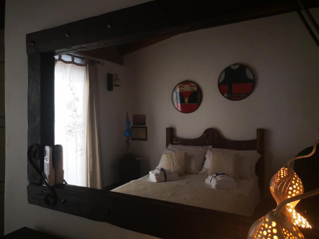 西尼斯科拉Domo Dizósa的镜子反射着卧室,卧室配有床和窗户