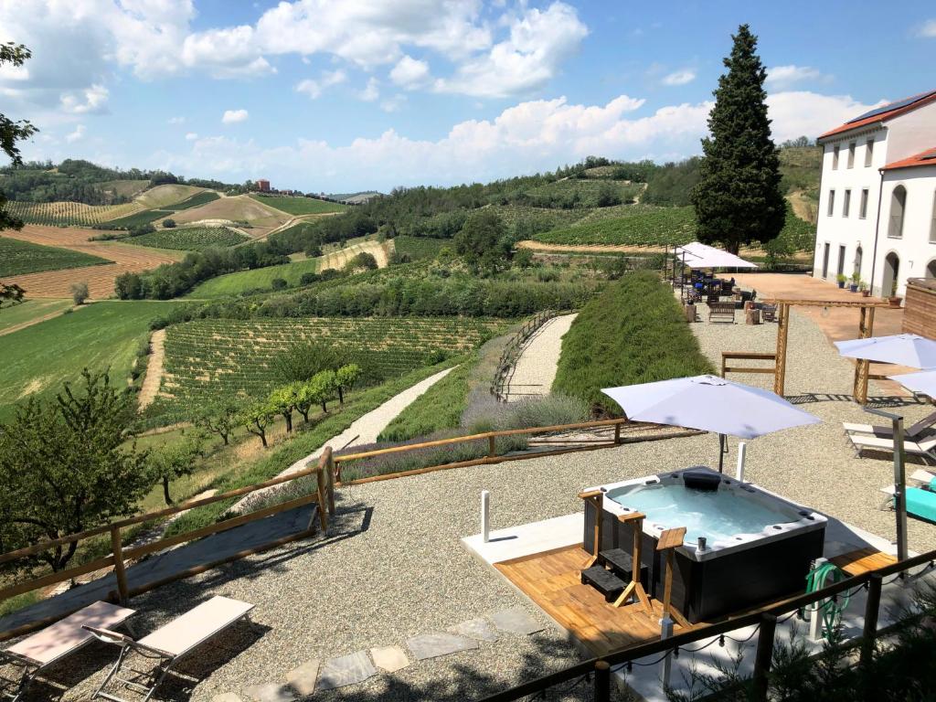 Ozzano MonferratoVilla Rocco Country House的阳台享有泳池和遮阳伞的景致。