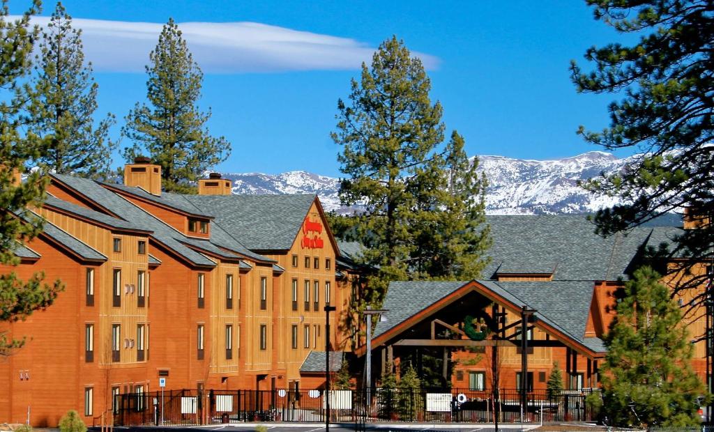 特拉基Hampton Inn & Suites Tahoe-Truckee的一座大砖砌建筑,背景是群山