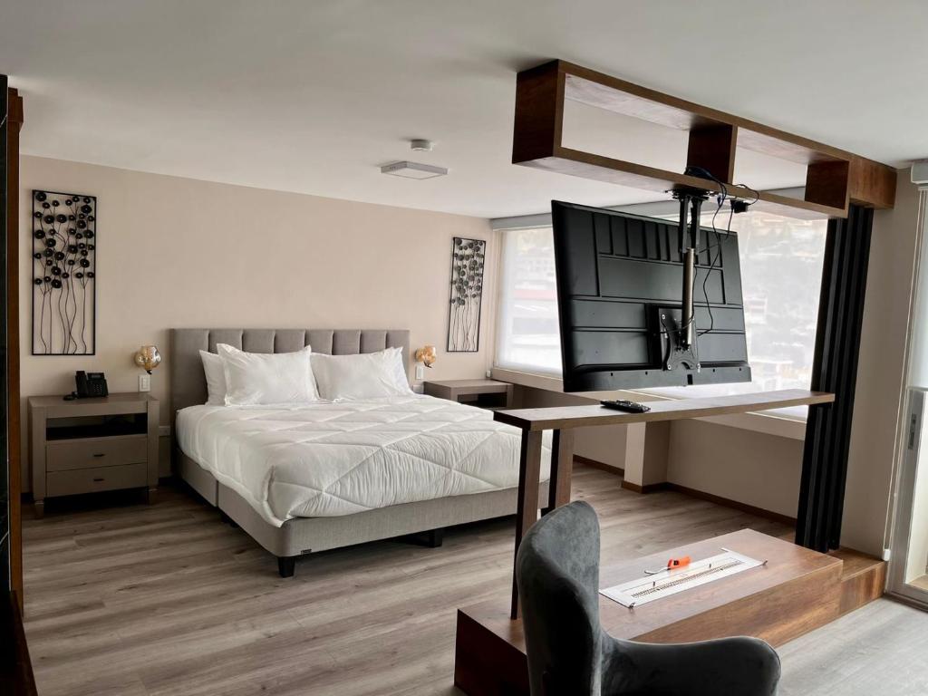 安巴托安巴托酒店的一间卧室配有一张床、一张书桌和一台电视