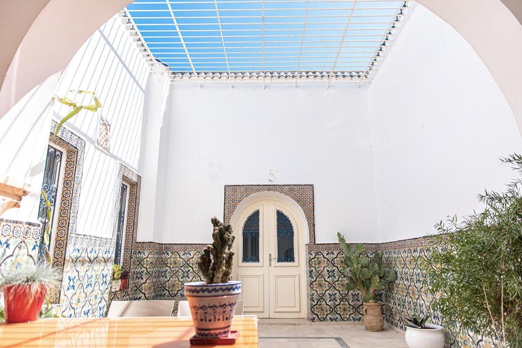 拉马萨Dar Mayya的一间设有门的房间和一张植物桌子