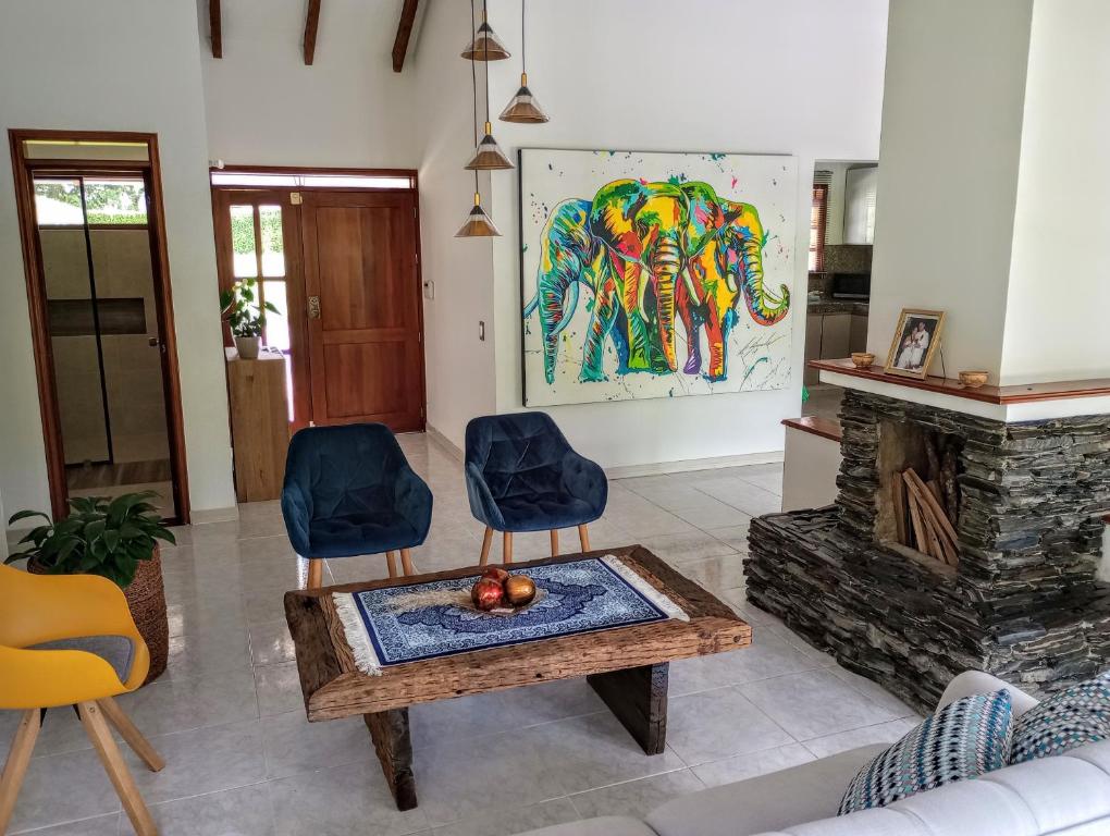 佩雷拉Habitación tranquila en casa campestre的客厅设有壁炉、桌子和椅子