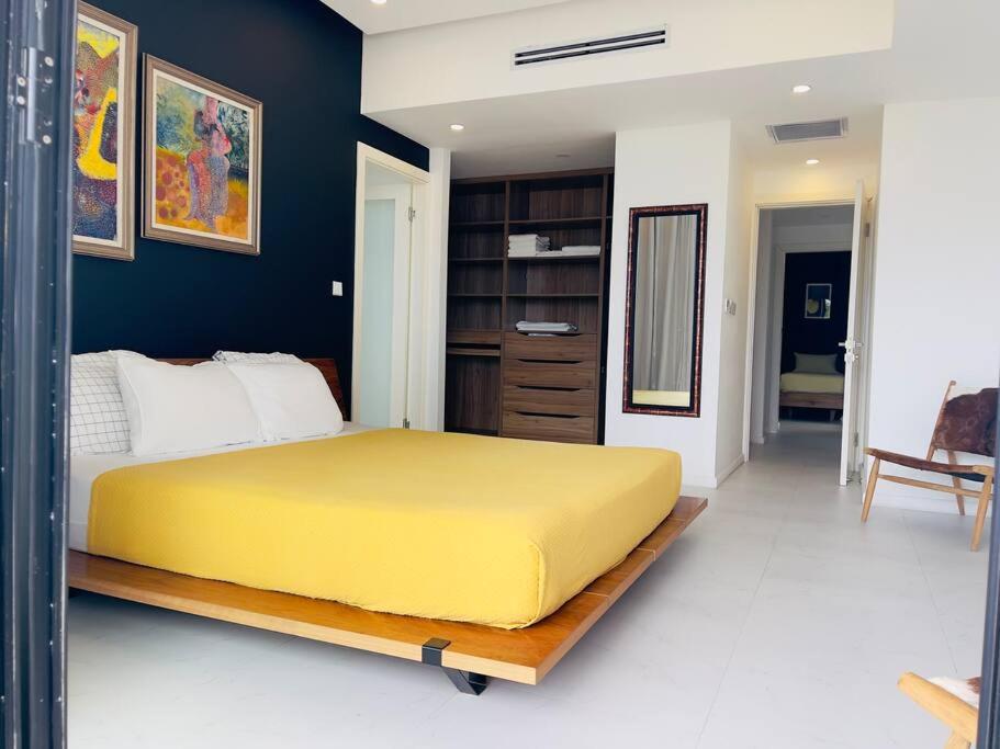蒙特哥贝Apt 6ix - Modern and Airy @ Paradise Bay的一间卧室,卧室内设有一张黄色的大床