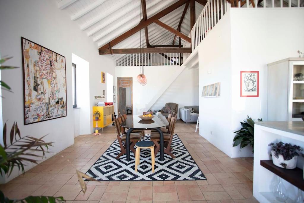 拉戈斯Casa na Curva - Artists Corner Country house的一间位于地毯上的带桌椅的用餐室