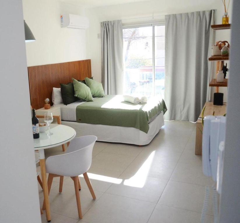 拉普拉塔Casa14的一间卧室配有一张床、一张桌子和一个窗户。