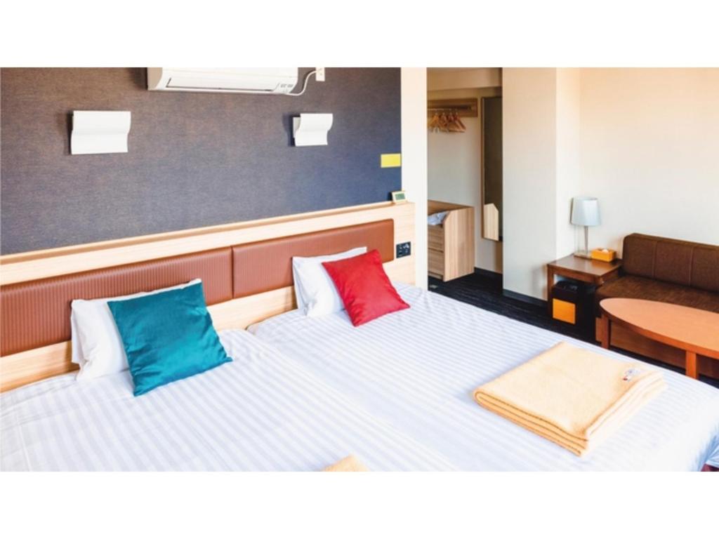 姶良市AIRAIKU HOTEL Kagoshima - Vacation STAY 17445v的客房配有带2个色彩缤纷的枕头的床。