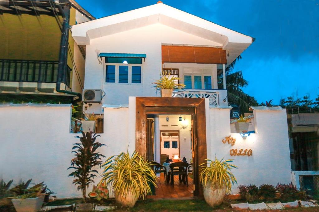 本托塔Luxury My Villa Bentota 200m Bentota Beach的白色的房子,前门有桌子