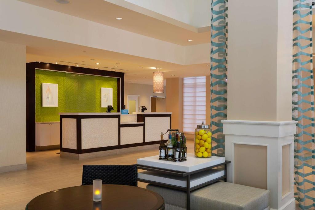 代托纳海滩代托纳海滩海滨希尔顿花园酒店的酒店大堂设有前台和桌子