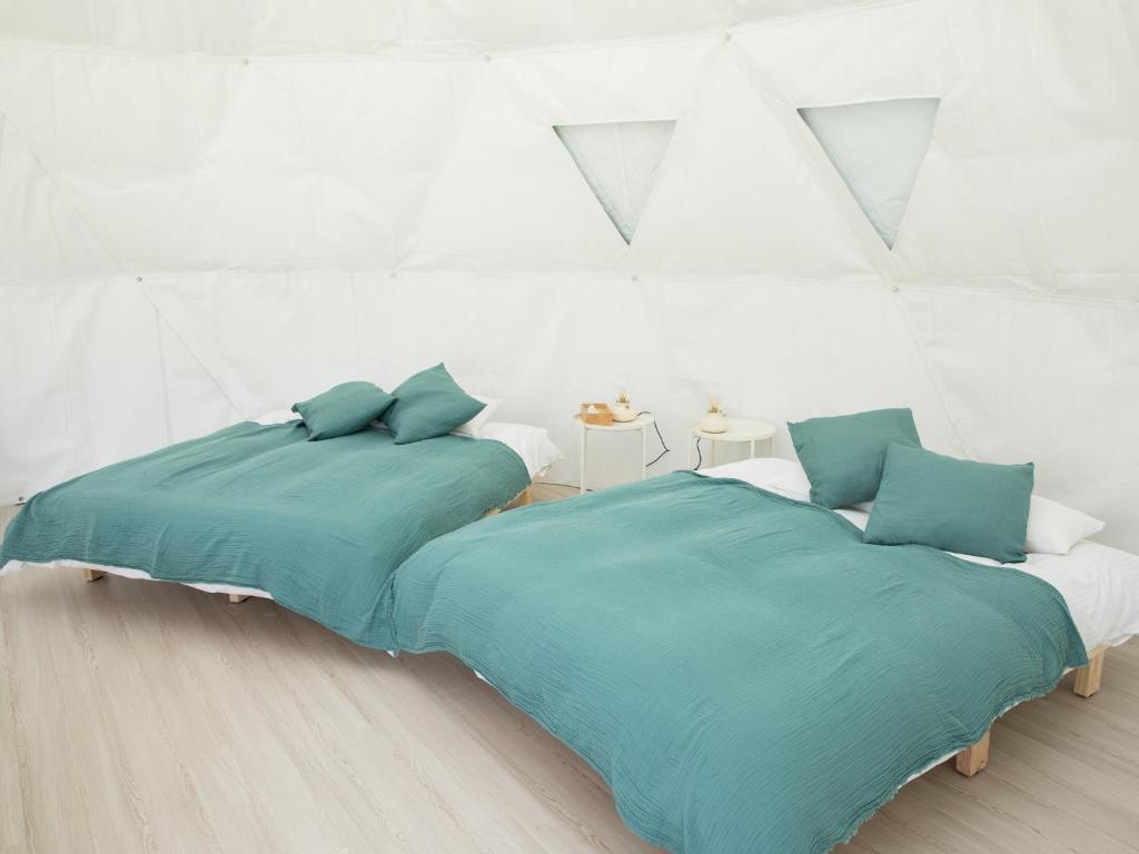 NomaBAMBOO RESORT MIHAMA TSUNAGI - Vacation STAY 43006v的白色客房的两张床,配有蓝色枕头