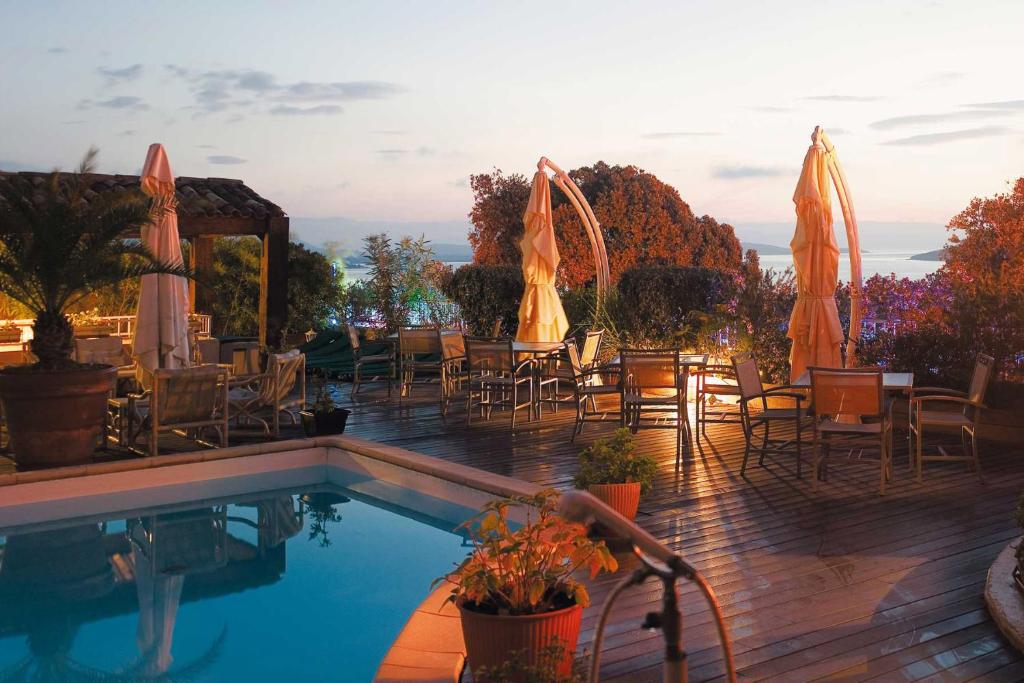 维琪奥港迪布里酒店的一个带桌椅和遮阳伞的游泳池