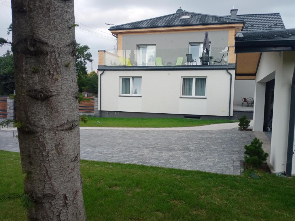苏瓦乌基Apartament 4U - Azyl Arkadia的前面有一棵树的白色房子