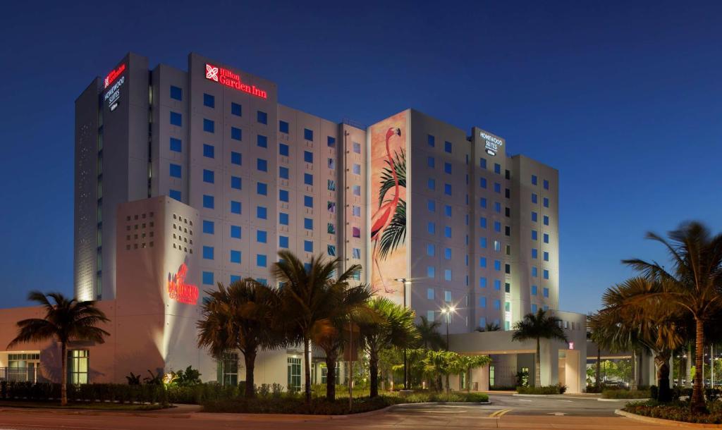 迈阿密迈阿密海豚购物中心希尔顿惠庭套房酒店的一座酒店大楼前面有棕榈树