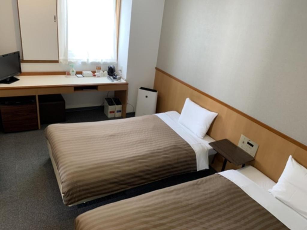 IrifunechōHotel Axia Inn Kushiro - Vacation STAY 67235v的酒店客房配有两张床和一张书桌