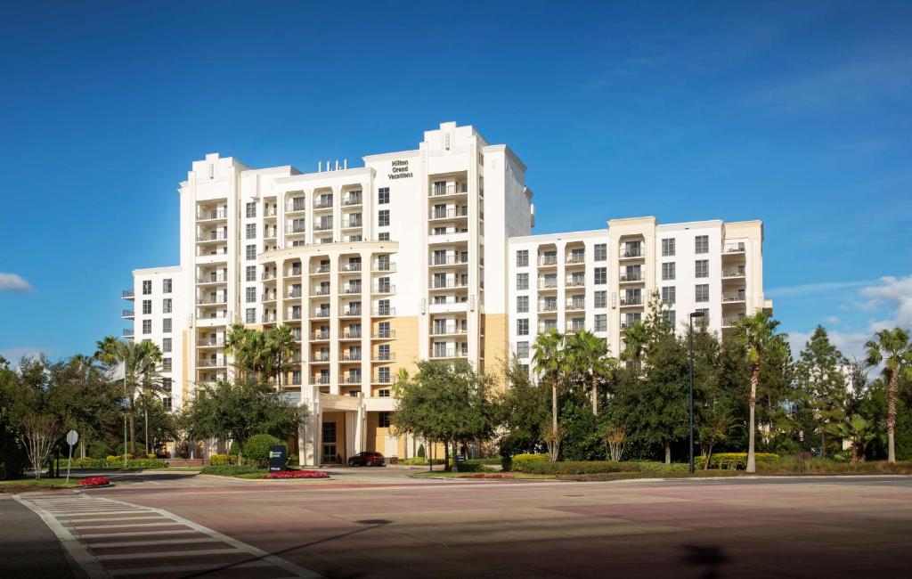 奥兰多Hilton Grand Vacations Club Las Palmeras Orlando的一座白色的大建筑,前面设有停车场