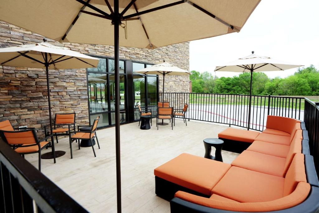Ponca CityHampton Inn & Suites Ponca City的一个带家具、桌子和遮阳伞的庭院