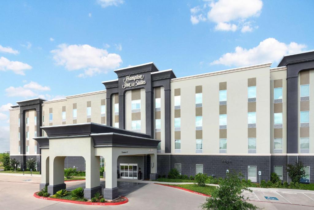 圣安东尼奥Hampton Inn & Suites San Antonio Brooks City Base, TX的一座白色的大建筑,上面有标志