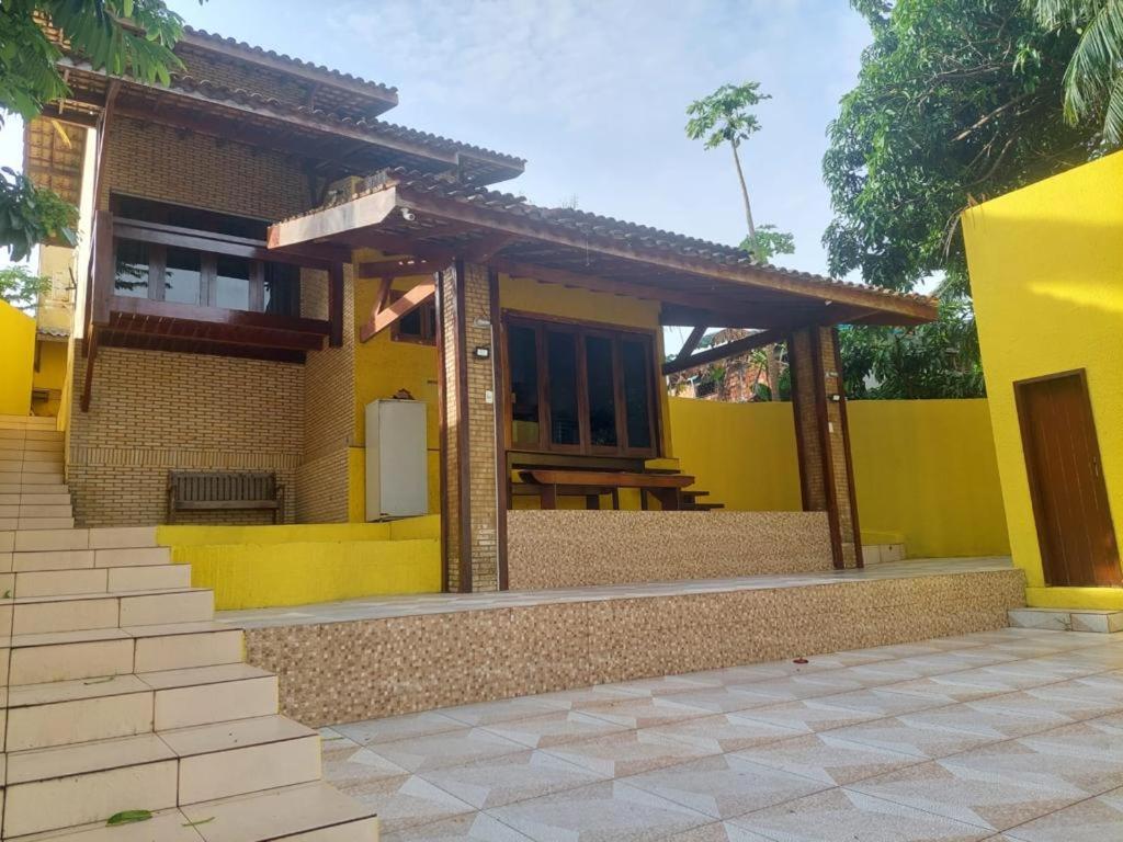 巴雷里尼亚斯Pousada Solar dos Lençóis的黄色的房子,前面有桌子