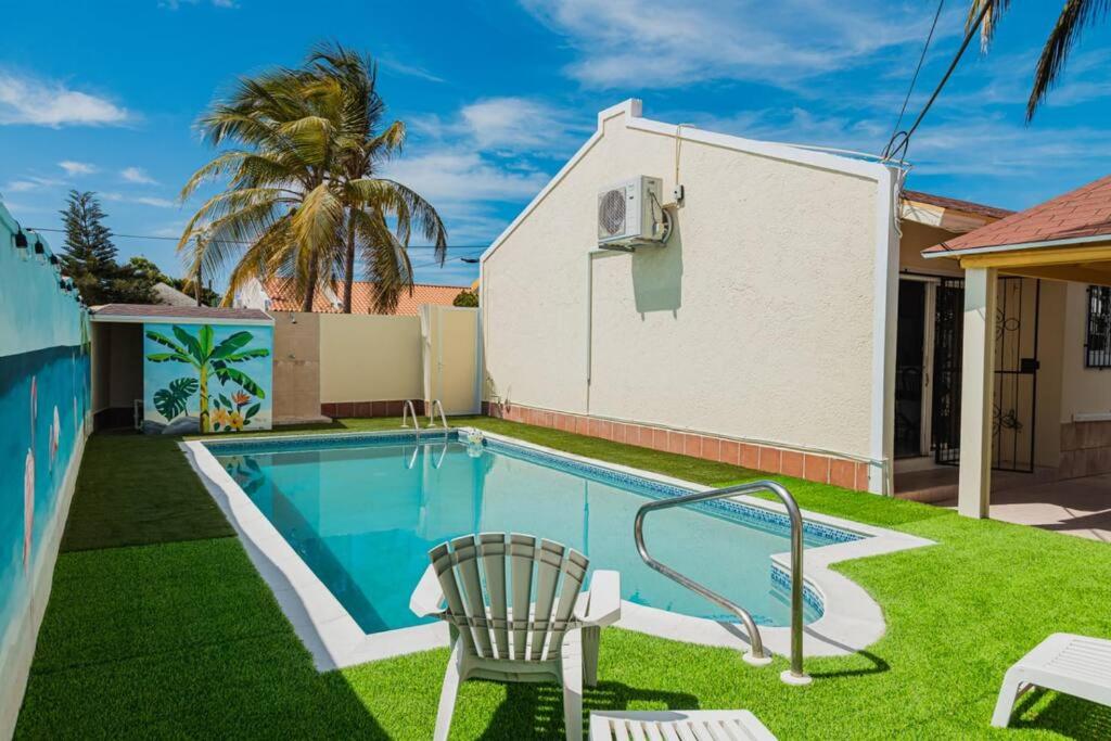 SavanetaBlue Sky Residence Aruba的房屋旁带椅子的游泳池