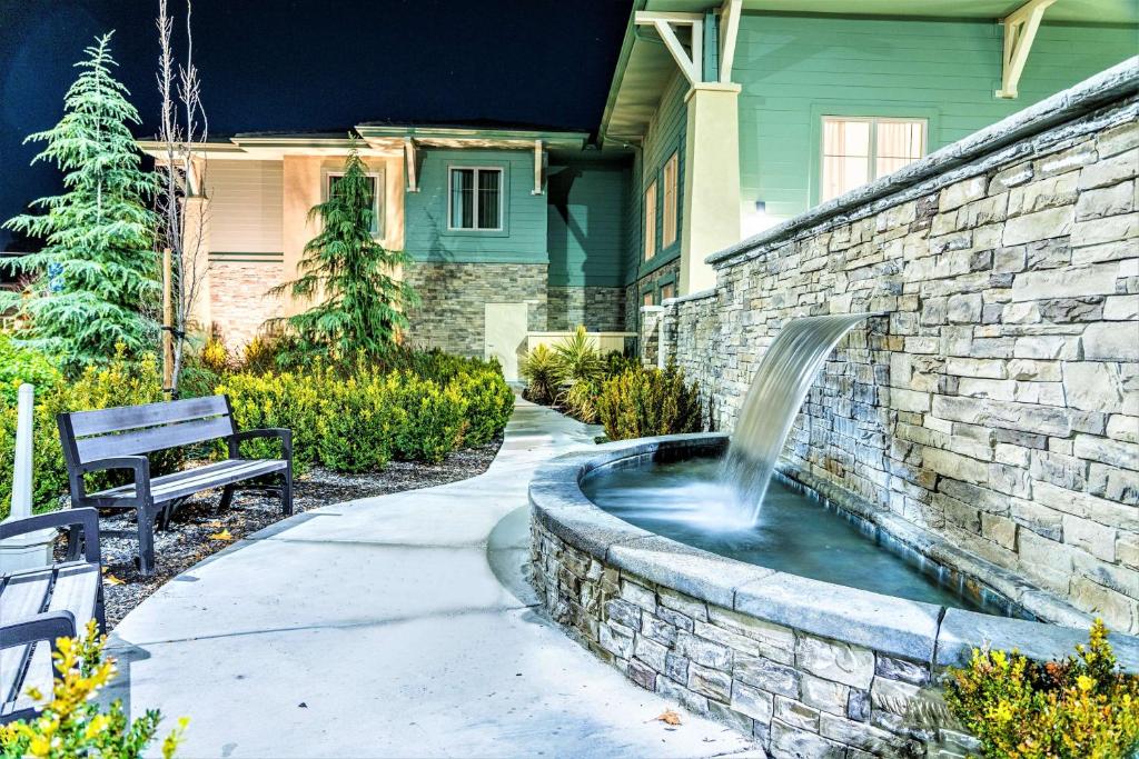 普莱森特希尔Homewood Suites by Hilton Pleasant Hill Concord的房屋前方带喷泉的石墙