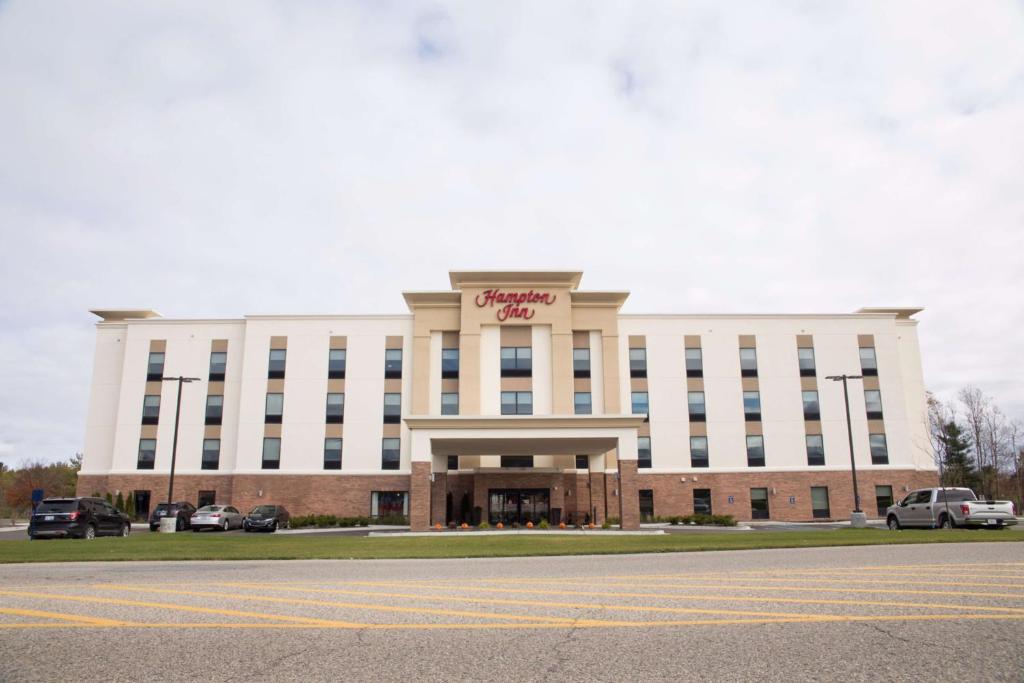 大瀑布城Hampton Inn & Suites Big Rapids, Mi的一座白色的大建筑,上面有标志