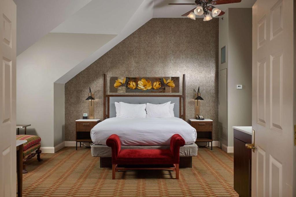 里士满弗吉尼亚十字酒店 - 希尔顿Tapestry Collection酒店的酒店客房,配有一张床和一张红色椅子