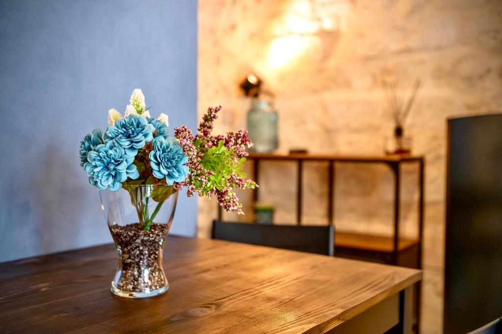 曼弗雷多尼亚Cà del Centro的花瓶里满是蓝色的花朵,坐在桌子上