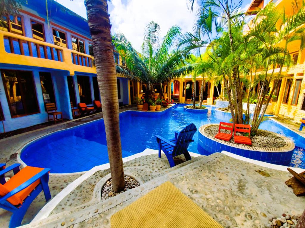Lance aux ÉpinesReef View Pavilions - Villas & Condos的一个带棕榈树和椅子的度假游泳池