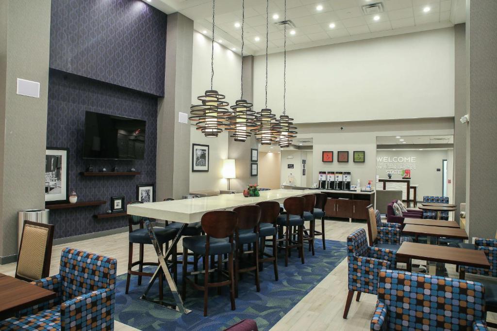 劳雷尔山Hampton Inn & Suites Mount Laurel/Moorestown的一间带长桌和椅子的餐厅