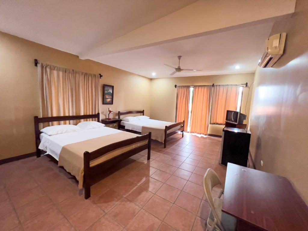 San AntonioBelen Suites的一间卧室配有两张床和电视。