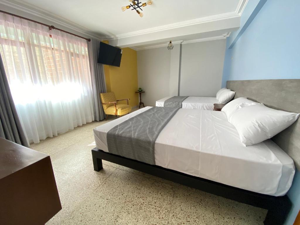 科恰班巴Izza Hotel的一间卧室设有两张床和窗户。
