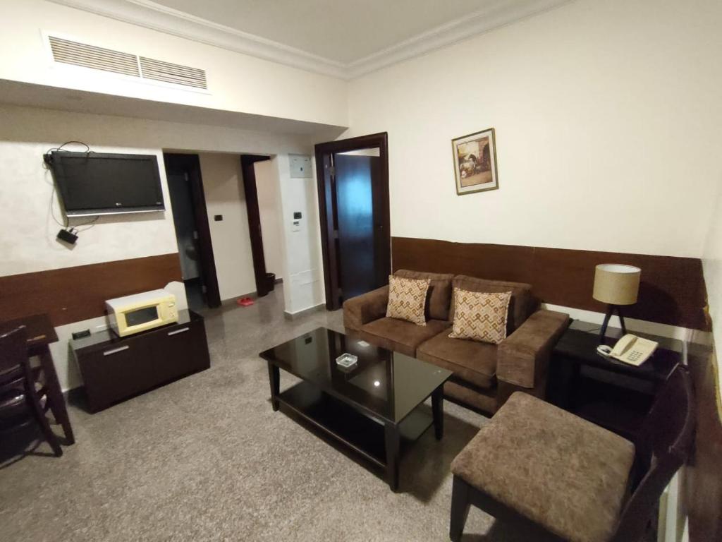 安曼Tamrah Suites Hotel的客厅配有沙发和桌子